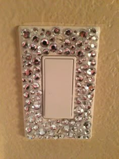 a light switch with lots of crystal stones on it