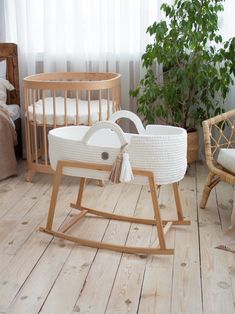 a baby's crib and rocking chair in a room with wooden floors, white curtains and windows