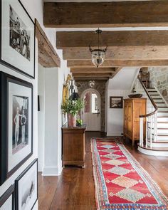 the hallway is decorated in white and wood with pictures hanging on the wall next to it