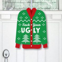 a green ugly ugly christmas sweater hanging on a door with a key in front of it