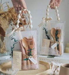 two plastic bags filled with wooden utensils on top of a table next to each other