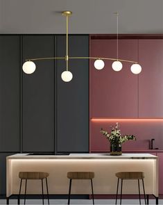 a kitchen with three stools and lights hanging from it's ceiling above the counter