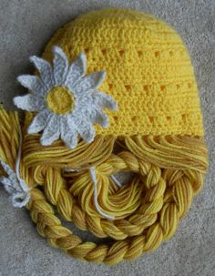 a crocheted yellow hat with white flowers on it