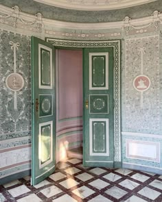 an open green door in a room with checkered flooring and wall paper on the walls