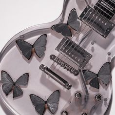 a guitar with several butterflies on the top of it's pickguards and strings