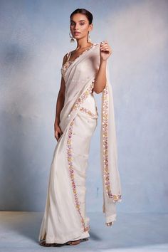 Off white padded blouse featuring floral hand embroidery all over with shell tassels on the waist hem. Paired with a hand embroidered pre-draped saree. - Aza Fashions White Pre-draped Saree With Floral Embroidery, Elegant Fitted Saree With Floral Embroidery, Festive Fitted Pre-draped Saree With Floral Embroidery, Festive Fitted Floral Embroidered Pre-draped Saree, White Silk Blouse Piece With Floral Embroidery, White Floral Embroidered Chanderi Pre-draped Saree, Embroidered Fitted Saree, Embroidered Fitted Draped Saree, White Silk Pre-draped Saree In Traditional Style