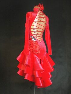 a red dress with long sleeves and ruffles on the skirt is displayed in front of a black background