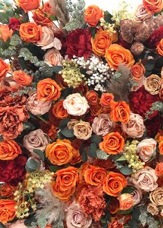 an arrangement of orange and red flowers in a vase