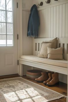 a bench with some shoes underneath it and a coat rack on the wall next to it