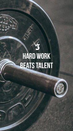 a close up of a barbell with the words hard work beats talent