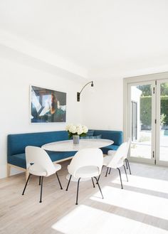 a dining room with white chairs and blue banquet table