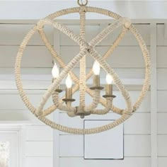 a chandelier hanging from the ceiling in a room with white walls and wood floors