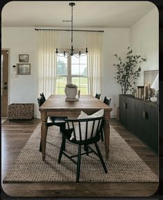 a dining room table with chairs and a rug on the floor in front of it