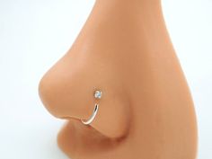 a nose ring with a single diamond on the top of it, sitting on a mannequin's head