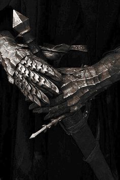 a black and white photo of a glove with spikes on it's palm, in the dark