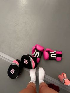 two pairs of pink and black boxing gloves on the floor