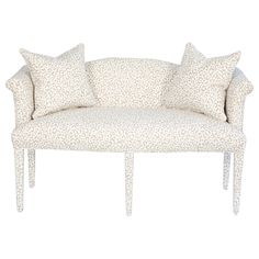 a white couch with leopard print pillows on it's back and two matching arms