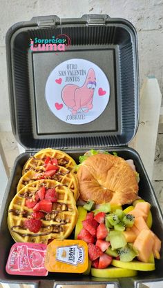 a bento box filled with fruit and waffles