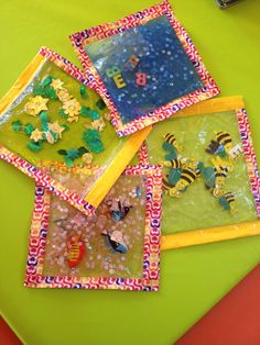 four different colored plates on a green table with scissors and other things in them,