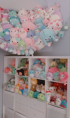 there are many small stuffed animals on the shelves in this room, and one is full of them