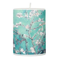 a teal candle with an almond blossoming tree on it