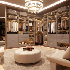 a large walk in closet with white furniture and chandelier