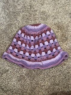 a crocheted hat is laying on the carpet