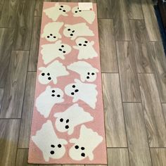 a pink rug with black and white dogs on it in front of a wooden floor