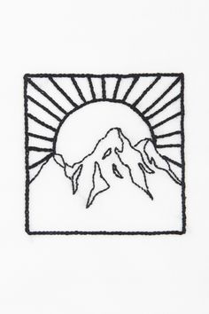 a white t - shirt with a black outline of mountains and the sun in the background