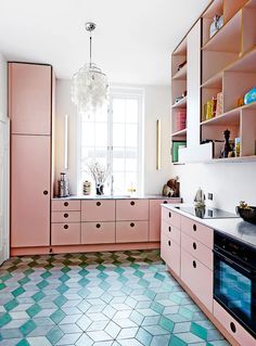 a kitchen with pink cabinets and white counter tops