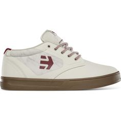 a white sneaker with brown soles and a red logo on the side,