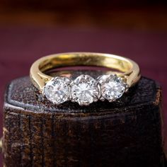 three stone ring sitting on top of a wooden box