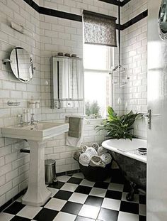 a bathroom with black and white tiles on the floor, tub, sink and mirror