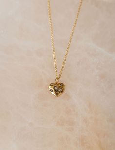 This delicate necklace features a scattering of sparkling CZ gems across a small heart pendant hanging on a dainty gold cable chain, making it the perfect accessory for any occasion. Adjustable 16-18" in length 12mm x 12mm amulet (approx) Heavy 18k Gold Plate over brass with e-coating for extra longevity ** Our pieces are plated 1 micron thick, industry standard is .125. Quality & longevity are extremely important to us. We wanted to ensure these pieces will last and work well for sensitive skin Gold Heart Charm Necklaces, Gold Heart Charm Necklaces With Heart Cut, Gold Heart Charm Birthstone Necklace, Gold Heart Cut Charm Necklace, Gold Birthstone Necklace With Heart Charm, Dainty Heart Pendant Birthstone Necklace, Gold Birthstone Necklace With Heart Charm For Valentine's Day, Gold Birthstone Necklace With Heart Cut For Valentine's Day, Gold Heart Cut Birthstone Necklace For Valentine's Day