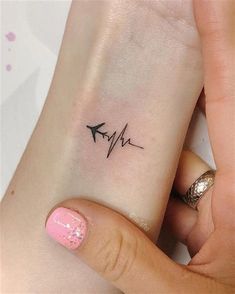 a woman's wrist with a heartbeat tattoo on it