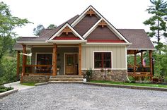 a house that is sitting in the middle of a gravel lot with trees around it