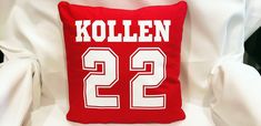 a red and white pillow with the number 22 on it is sitting on a chair