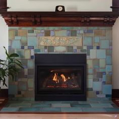 a fireplace with a clock on the mantle above it and a potted plant next to it