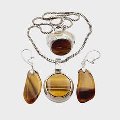 NO. 1693(1) Three vintage pieces of silver jewelry charming Tiger's Eye stone: Necklace: Hallmark: 835 Size: approx. 38 cm - Pendant: approx. 29 x 18 mm (eyelet included) Weight: 11.82 g Earrings: Hallmark: - / at least 800 silver tested Weight: 2.68 g Size: approx. 26 x 11 mm Ring: Hallmark: 835 Size: Ring: Ø approx. 55 (adjustable) - ring top head: approx. 16 x 16 mm Weight: 5.81 g Note: We sell antique/vintage pieces of jewelry, so there might be some signs of wear due to their age. Please lo Classic White Gold Jewelry With Stones, Classic Silver Jewelry With Stones, Classic Sterling Silver Jewelry With Stones, Sterling Silver Jewelry With Stones For Formal Occasions, Formal Sterling Silver Jewelry With Stones, Costume Jewelry Pendant With Cabochon, Pendant Stones For Jewelry Making, Polished Metal Jewelry Gift, Round Cabochon Costume Jewelry