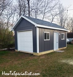 a garage with two doors on the side of it and a shed in the background