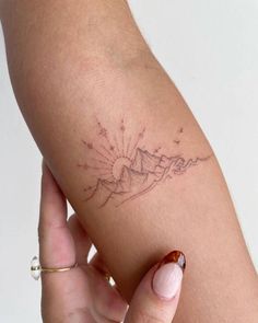 a woman's arm with a small tattoo on the left side of her arm