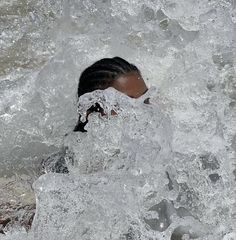 a woman in the water with her face covered by ice