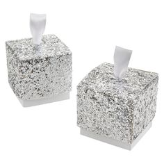 two tissue dispensers sitting next to each other on top of a white surface