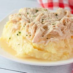 a white plate topped with mashed potatoes covered in chicken