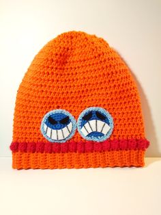 an orange knitted beanie with two blue eyes