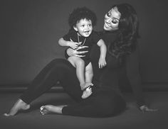 a woman holding a child while sitting on the floor