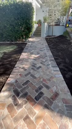 a brick walkway in front of a house