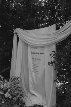 a white sheet draped over some bushes and trees in black and white with the words lautrionia written on it