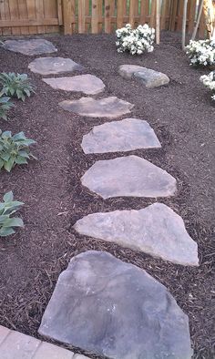 a stone path in the middle of a garden