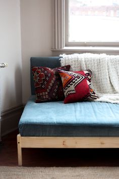 a couch with pillows on it in front of a window